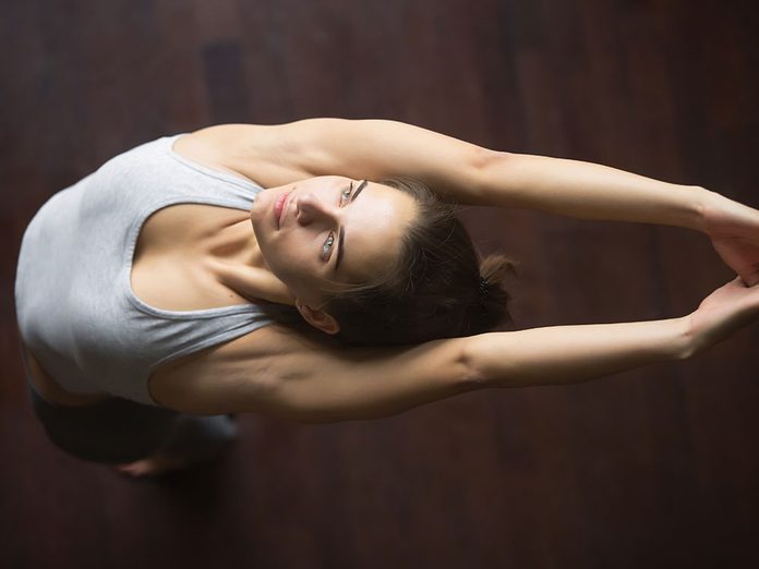 Essayez la posture de yoga de la montagne avec les bras levés pour retrouver de l'énergie.