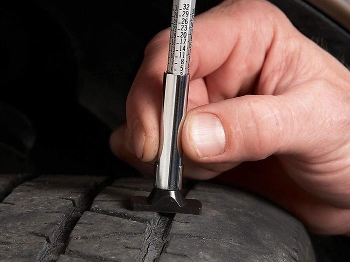 Vérifier la profondeur de la bande de roulement des pneus pour préparer sa voiture pour l'hiver.