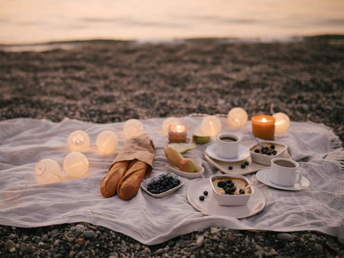Romantic,picnic,by,the,sea,at,sunset,decorated,with,garland.
