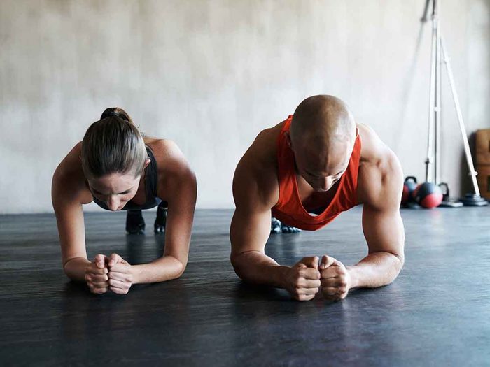Un homme et une femme font des exercices abdominaux.