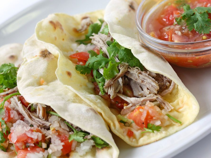 Des tacos garnis des principaux ingrédients: salsa, protéines et les légumes.