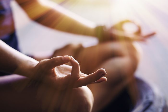 Personne qui pratique la méditation: gros plan sur ses mains.