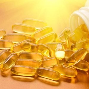 Gélules de vitamines D illuminées par un rayon de soleil.