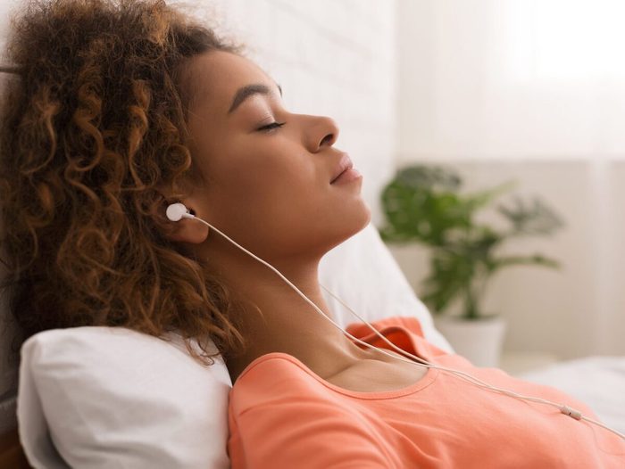 Une femme relaxe en écoutant de la musique et des berçeuses.
