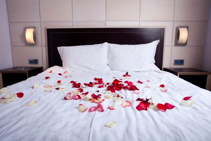Des pétales de roses sur le lit.