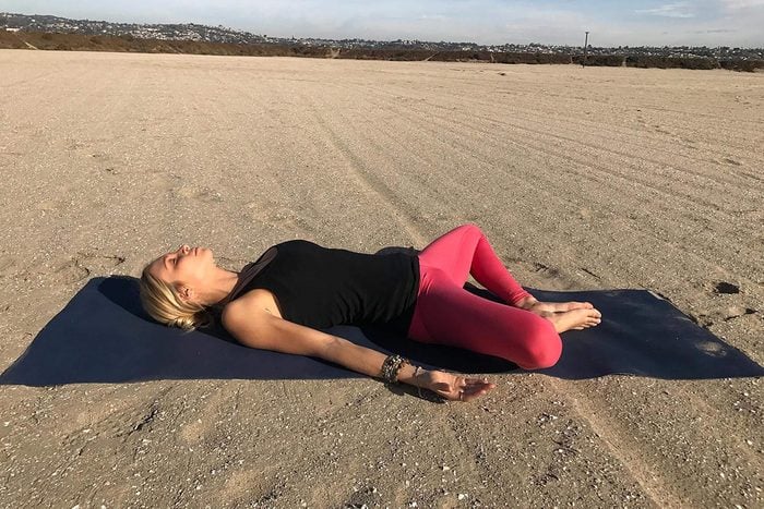 Position de yoga pour la digestion : position de relaxation sur le dos, jambes ouvertes.
