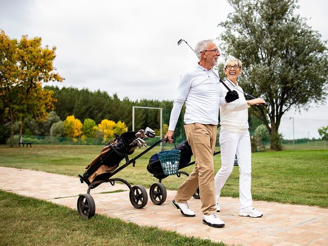 Un couple se dirige vers un terrain de golf pendant leurs vacances