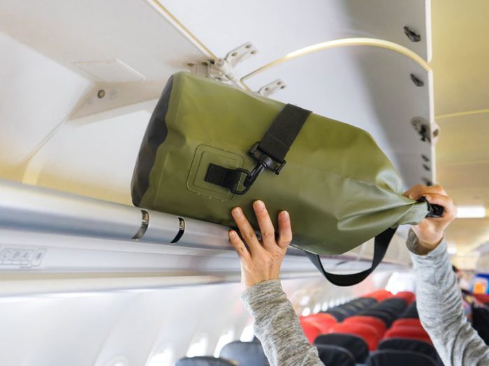 Monopoliser le porte-bagages est un comportement impoli à éviter en avion.