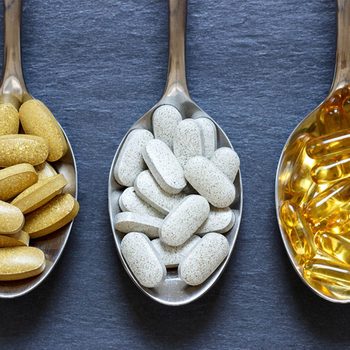 Des vitamines, des minéraux et des médicaments dans trois cuillères différentes.