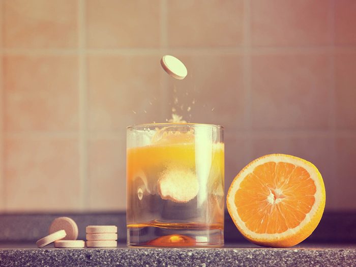 Une pilule de vitamine C tombe dans un jus d'orange.