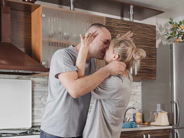 Couple heureux qui s'embrasse dans la cuisine.