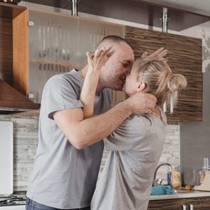 Couple heureux qui s'embrasse dans la cuisine.