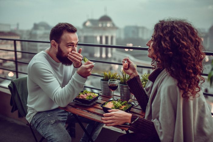 Couple riant et s'amusant en mangeant au restaurant.