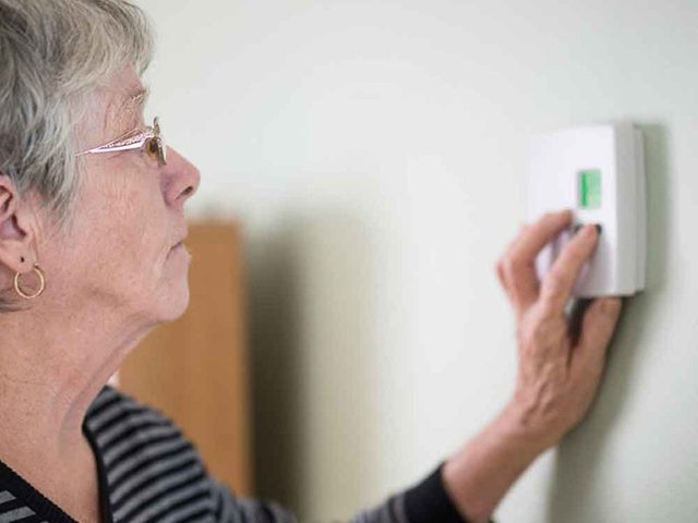 Climatisation: une dame arrange la temprature de son thermostat