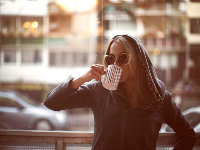 Une femme boit son caf.