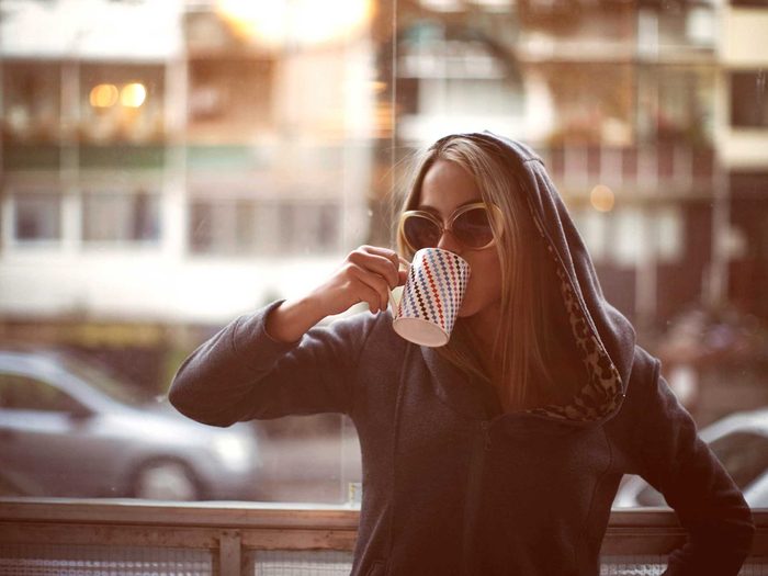 Une femme boit son café.