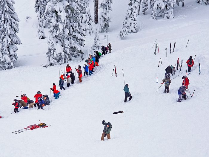 Cinquante sauveteurs, patrouilleurs en combinaison de ski rouge et bénévoles cherchent des survivants après la deuxième avalanche.