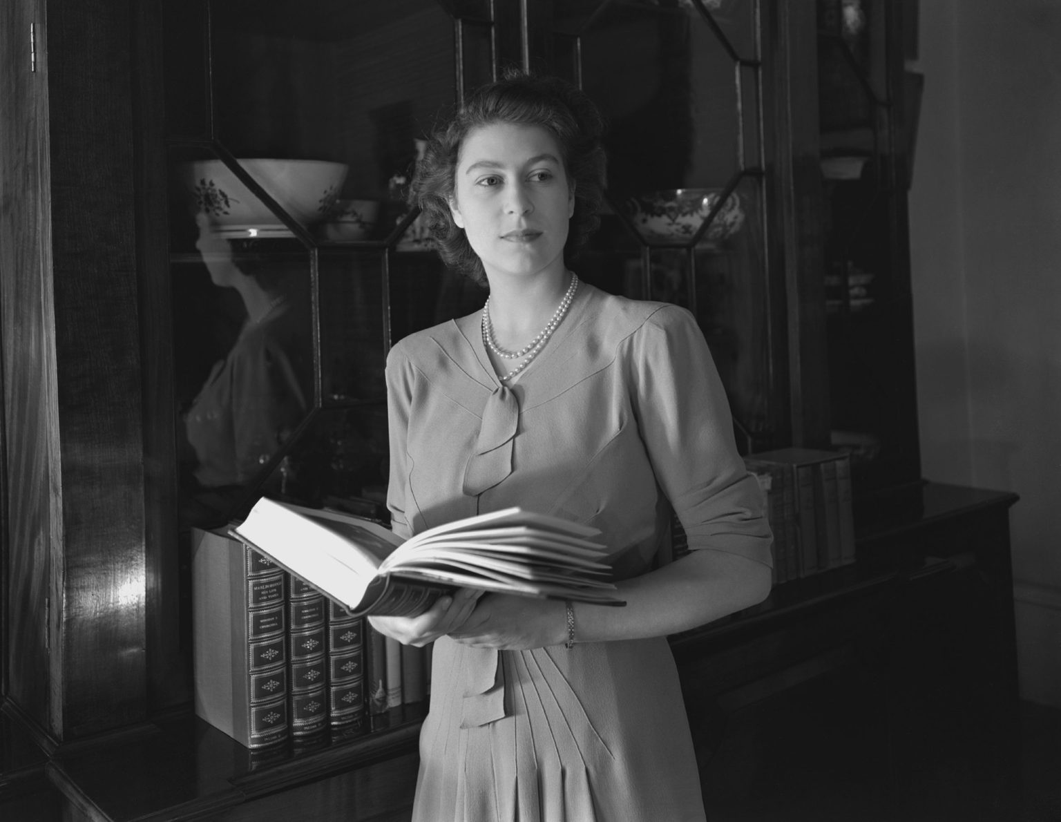 La reine Elizabeth pose avec un livre