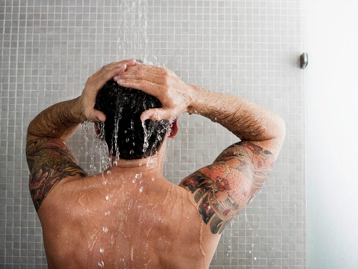 Homme se lavant les cheveux sous la douche
