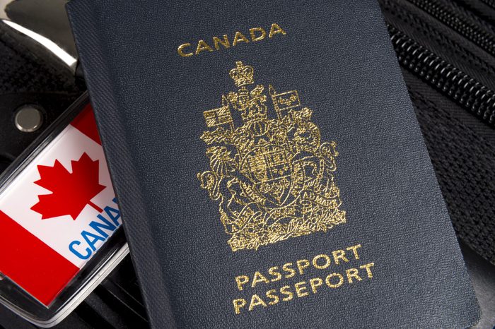 Closeup,of,canadian,passport,sitting,on,suitcase,with,maple,leaf