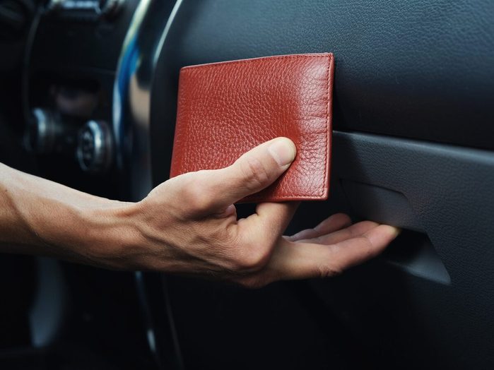 Man Hand Puts Leather Wallet In The Glove Compartment Box Inside Car.