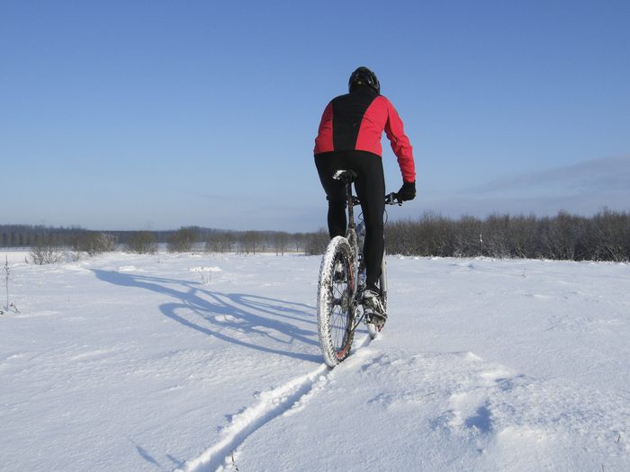 Un cycliste fait du vélo d'hiver avec un vélo tout-terrain.