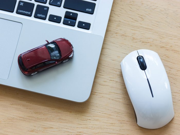 Car,model,on,notebook,and,mouse,on,wooden,desk.,about