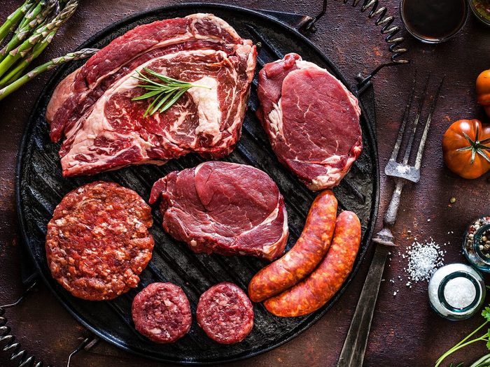 Various Cuts Of Raw Meat Shot From Above On A Cast Iron Grill