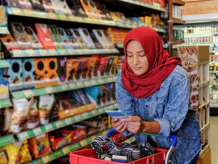 Modern Muslim Woman Buying Chocolate Bar