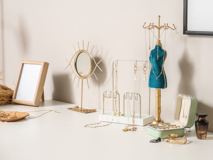 Different,stands,with,stylish,jewelry,and,photo,frames,on,table