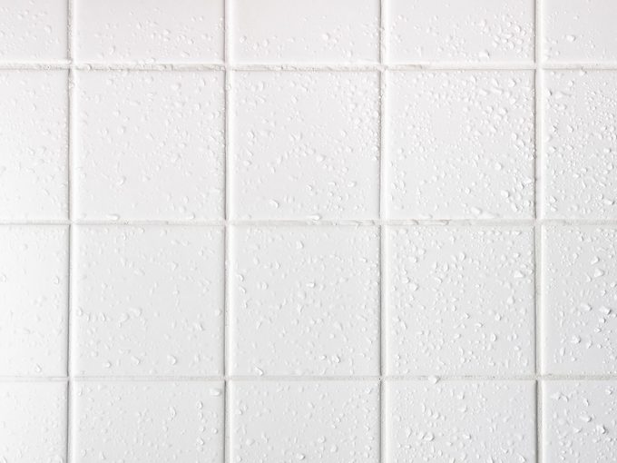 Un mur de céramique blanche, couvert d'eau