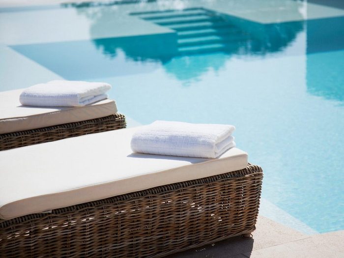 Folded Towels On Lounge Chairs Beside Pool