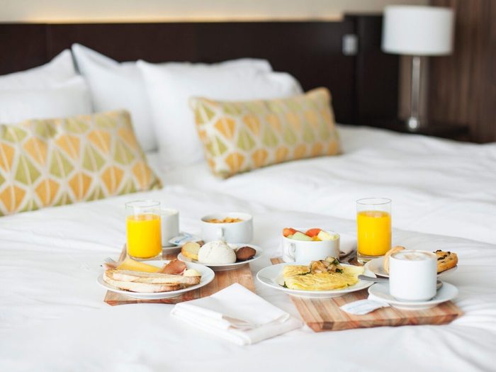 Breakfast Trays On Bed In Luxury Hotel Room