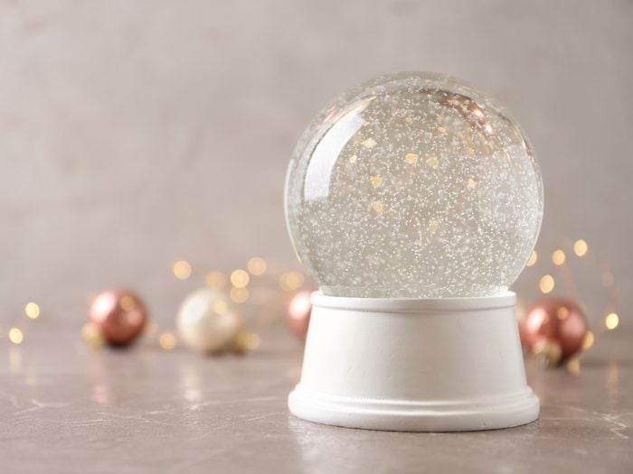 Snow,globe,and,christmas,decorations,on,marble,table,against,festive