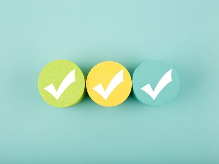 Three White Checkmarks On Colorful Circles Against Bright Aqua Blue Background