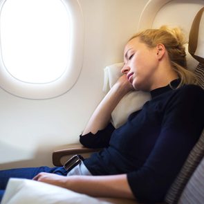 Une dame dort dans l'avion.