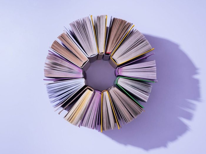 Top View Of Stack Of Books In Circle On Violet Tabletop
