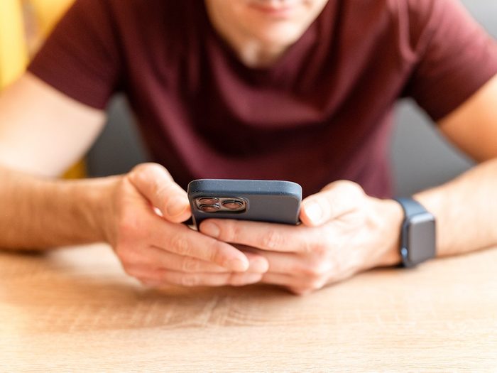 Un homme tient un téléphone dans ses mains.