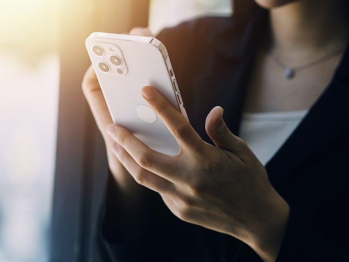 Une femme avec un téléphone dans la main.