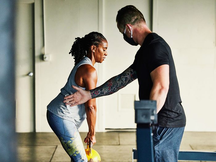 Un coach aide une femme à s'entraîner.