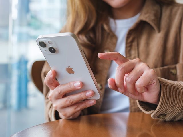 Astuces iPhone: une femme avec un tlphone dans la main.