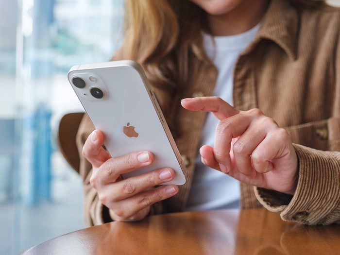 Astuces iPhone: une femme avec un téléphone dans la main.