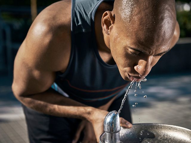 Hygine salle de gym: un homme boit de l'eau.