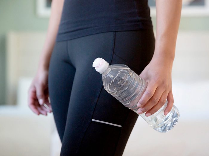 Hygiène salle de gym: une personne tient une bouteille d'eau dans sa main.