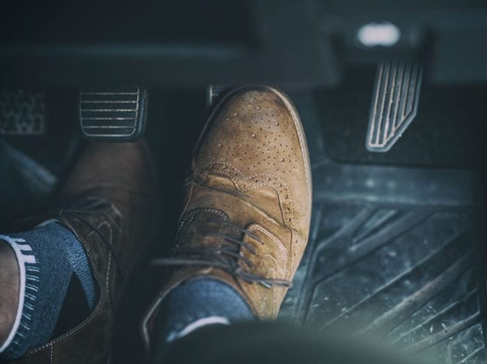 Voiture en fin de vie: photo de bottes d'un conducteur.
