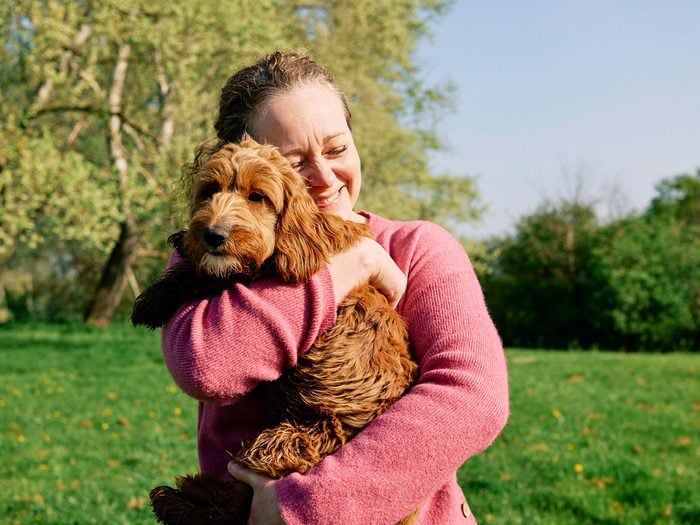 Races de chien pour anxiété: une femme donne un câlin à son chien.