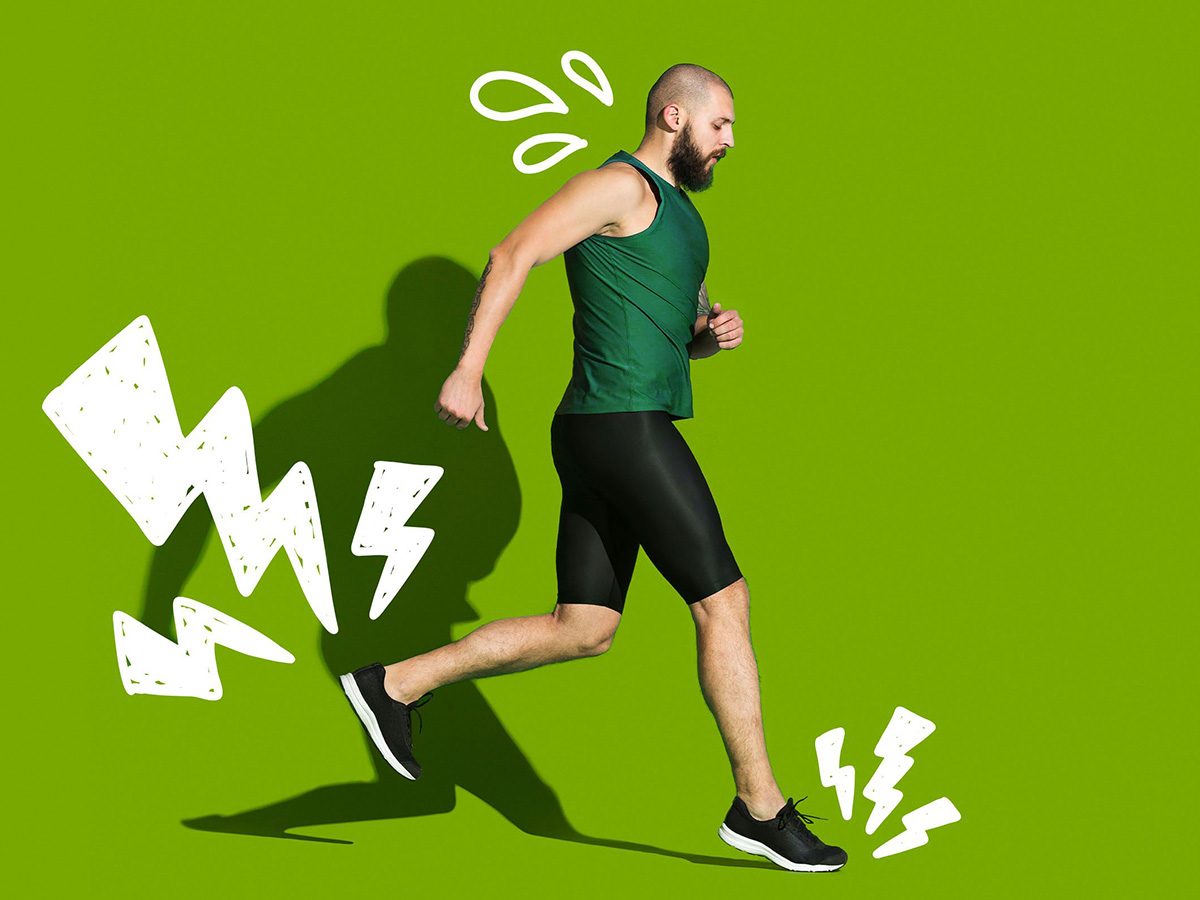 Un homme en train de courir devant un arrière-plan vert.