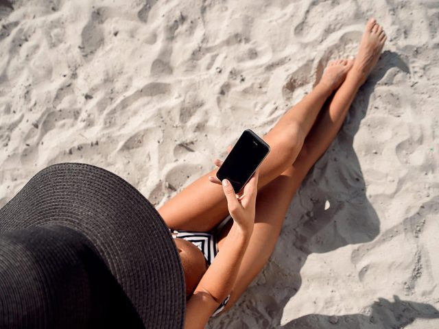 recharger rapidement son tlphone: une personne utilise son cellulaire  la plage.