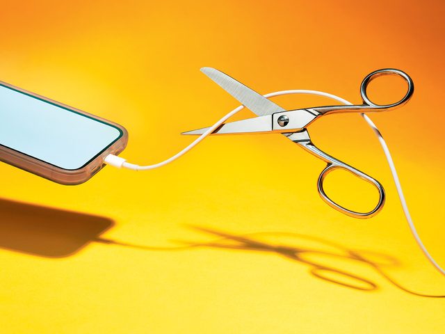 Vivre sans Internet: une photo de ciseaux qui coupent un fil d'iPhone.