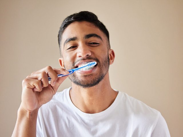 Habitudes dentiste: un homme qui se brosse les dents.